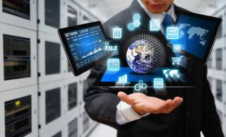 Homme qui tend la main au dessus de laquelle sont des hologrammes représentant la planète terre autour de laquelle sont disposés 3 tablettes ainsi que divers icônes informatiques pour la corbeille, les sms, le web, une horloge, un caddie, la configuration...le tout indiquant que tout lui tient dans le creux de la main