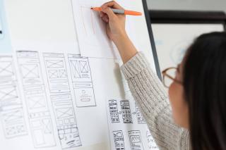 Femme qui dessine au tableau blanc les différentes vues d&rsquo;un site