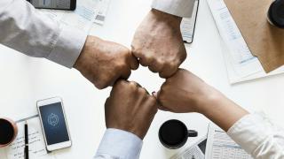 3 hommes et 1 femme se checkent le point pour accord: tous le monde est ok